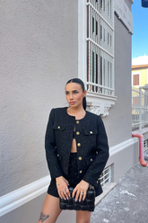 a lady wears a black tweed jacket with a matching skirt